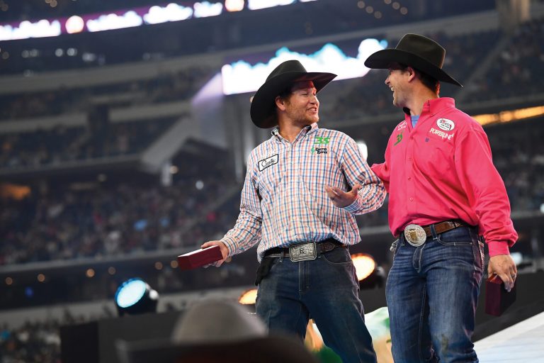 Andrew Ward and Buddy Hawkins walk across the stage after winning the 2022 The American Rodeo.