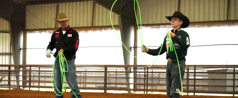 Manny Egusquiza and Denton Parrish practice on a roping dummy.